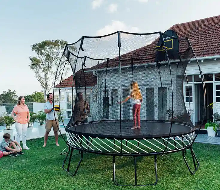 family playing around a trampoline