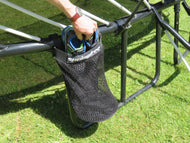 Load image into Gallery viewer, placing shoes inside a storage bag attached to a trampoline
