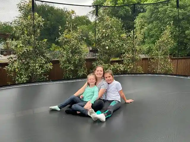 girls sitting on a trampoline
