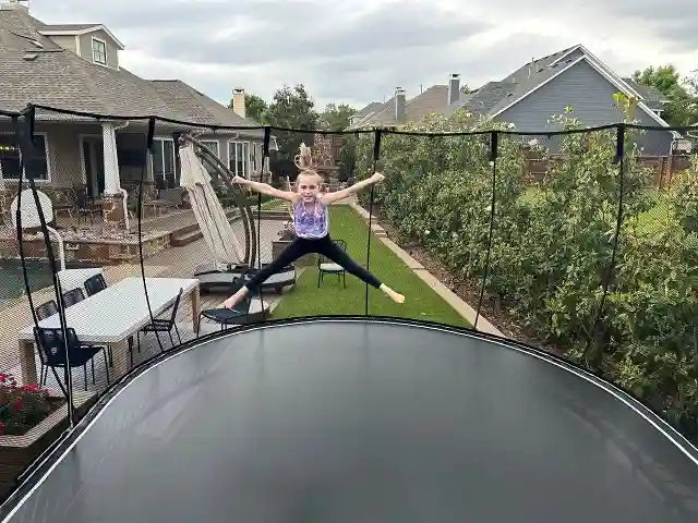 girl jumping on an outdoor trampoline