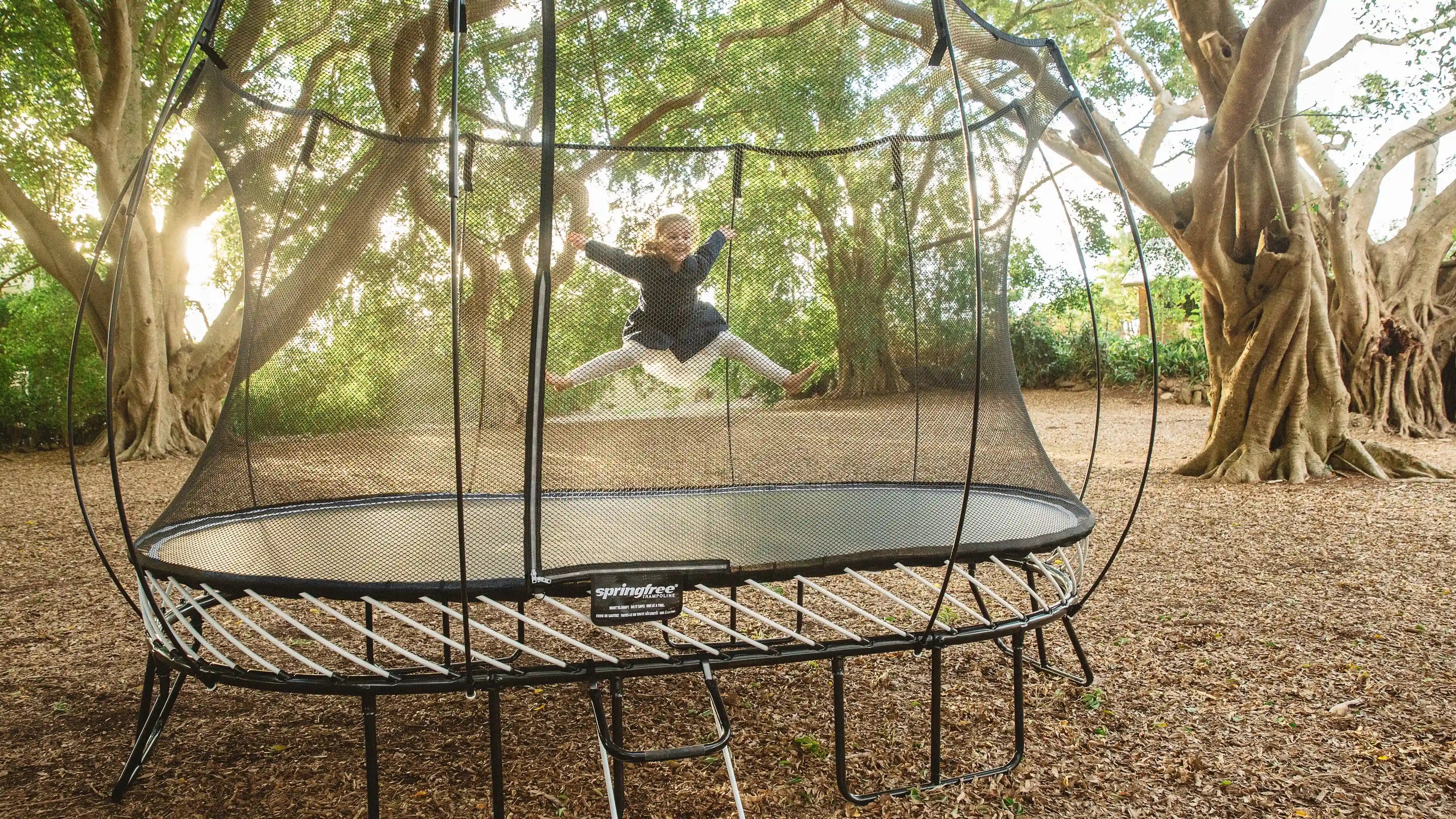 girl jumping on an outdoor trampoline